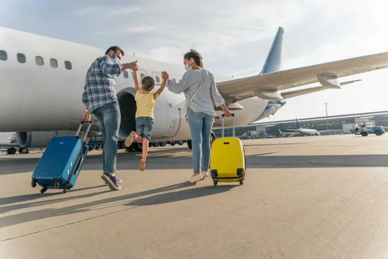 Parents et petite fille avec leur valise devant un avion pour un tour du monde