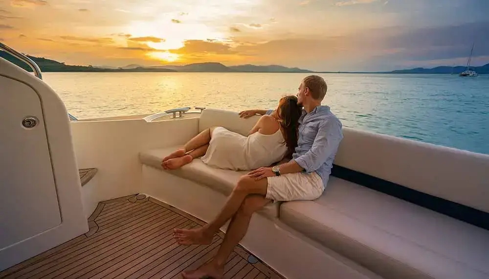 Vacances romantiques, un couple s'enlace devant un coucher de soleil dans une croisière de luxe