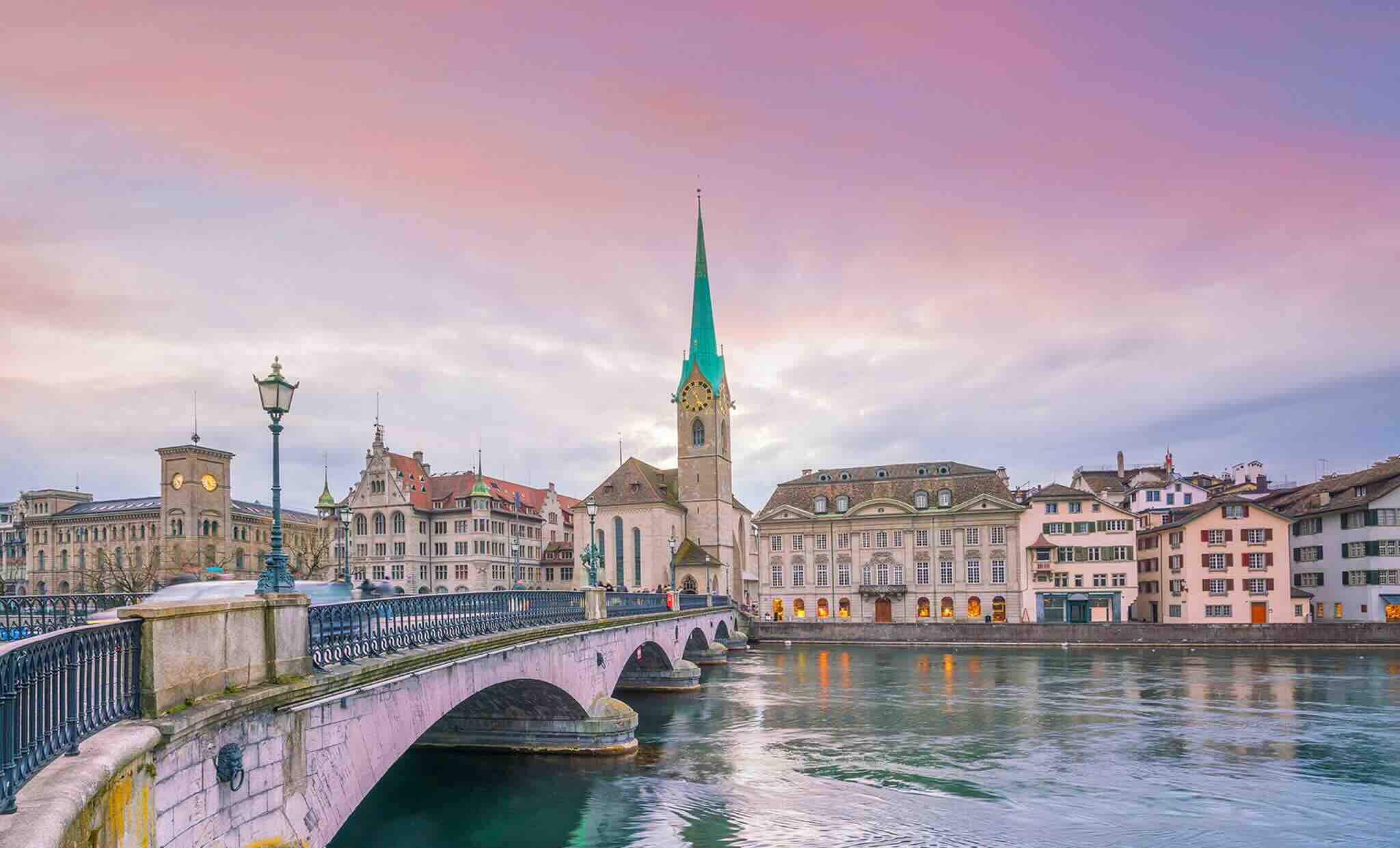 Pont et monuments de Zurich en fin de journée, sous un ciel rose